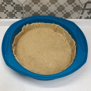 Раскатать тесто для клюквенного пирога и переложить его в форму для запекания